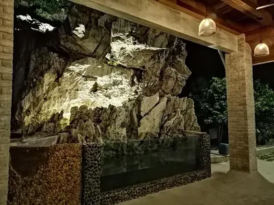a rock wall in front of a building at Rocky Farm in Ipoh