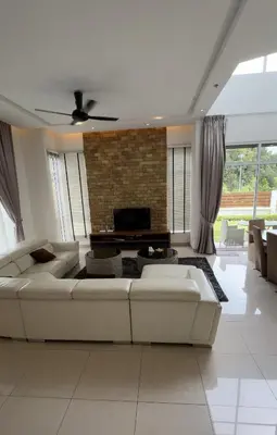 a living room with a white couch and a fireplace at Zinnia Residence Tanah Rata in Cameron Highlands