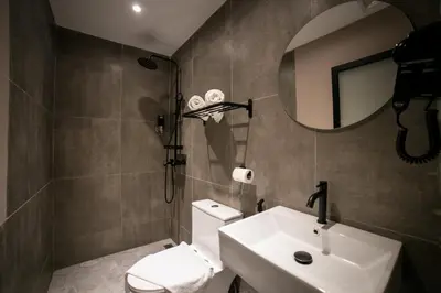 a bathroom with a sink and a toilet and a mirror at Eureka Hotel Penang in Bayan Lepas