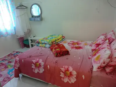 a bedroom with a pink bed with flowers on it at Cameron Highlands Muslim Apartment by AziziCameron in Cameron Highlands