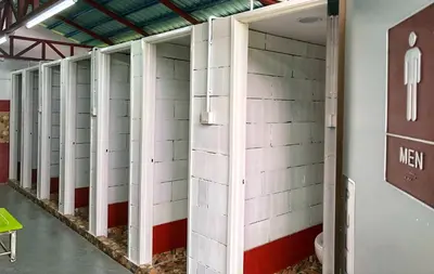a row of stalls in a room with white tiles at Kea Garden Mini Chalet in Cameron Highlands