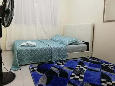 a bedroom with two beds and a blue blanket on the floor at A1-04-03 Damiana Apartment in Tanjung Malim
