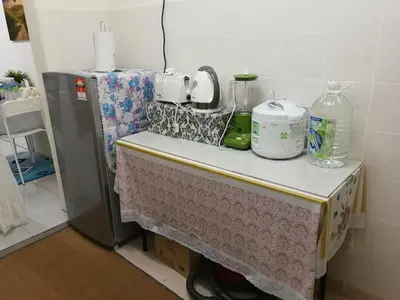 a table with a table cloth on it next to a refrigerator at A1-04-03 Damiana Apartment in Tanjung Malim