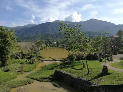 a river in a field with mountains in the background at A1-04-03 Damiana Apartment in Tanjung Malim
