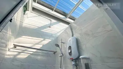 a white bathroom with a shower and a window at 24 Kimberley in George Town