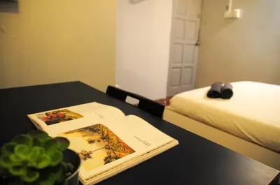 a bedroom with a table with a book and a bed at GRAYHAUS SOHO Ipoh in Ipoh