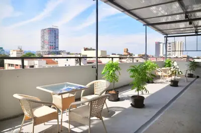 a balcony with chairs and a table on a roof at GRAYHAUS SOHO Ipoh in Ipoh