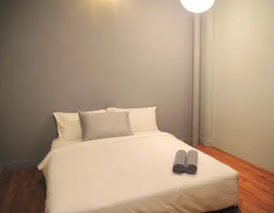 a bed with two pairs of slippers on it at GRAYHAUS SOHO Ipoh in Ipoh