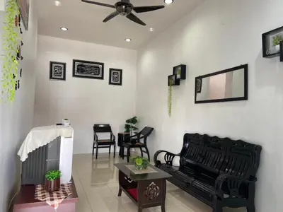a living room with black chairs and a ceiling fan at Abg Long Fadhil Homestay in Sungai Petani