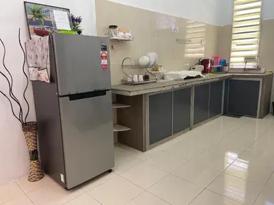 a kitchen with a stainless steel refrigerator and a counter at Abg Long Fadhil Homestay in Sungai Petani