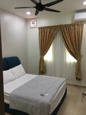 a bedroom with a bed and a ceiling fan at CK Homestay K.Sepetang in Taiping