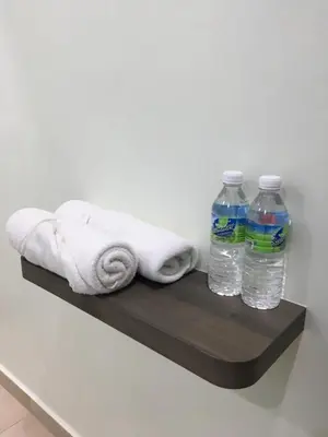 a shelf with towels and bottles of water on it at CK Homestay K.Sepetang in Taiping