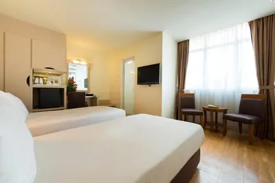a hotel room with two beds and a television at Hotel Sentral Georgetown @ City Centre in George Town