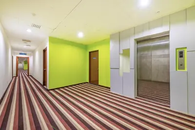 an empty hallway with green and yellow walls at Northern Lodge Hotel in Sungai Petani