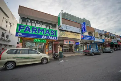 a street with cars parked in front of buildings at Northern Lodge Hotel in Sungai Petani