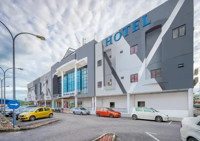 a hotel with cars parked in a parking lot at Northern Lodge Hotel in Sungai Petani
