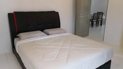 a large bed with a black headboard in a room at My Home Apartment - The Quintet Condo in Cameron Highlands