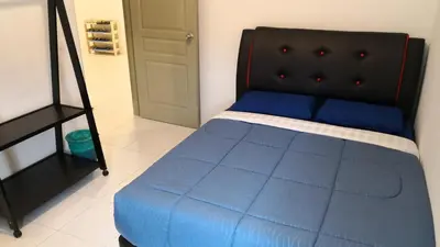 a bedroom with a blue bed with a black headboard at My Home Apartment - The Quintet Condo in Cameron Highlands