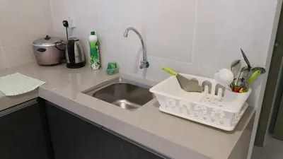 a kitchen sink with a dish rack next to it at My Home Apartment - The Quintet Condo in Cameron Highlands