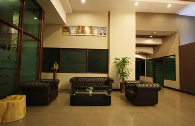 a waiting room with leather chairs and a table at Aroma Hotel in Butterworth