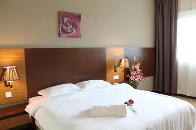 a bedroom with a large white bed with flowers on it at Aroma Hotel in Butterworth