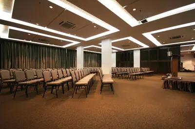 a room with rows of chairs and a podium in front of a screen at Aroma Hotel in Butterworth