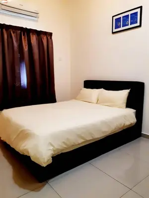 a bedroom with a large bed with a black headboard at Ipoh EastEden Homestay in Ipoh