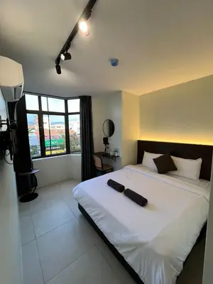 a bedroom with a large white bed with a large window at Hotel Seri Kangsar KK Hotel in Kuala Kangsar