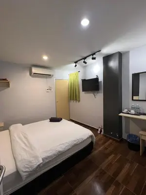 a bedroom with a white bed and a television at Hotel Seri Kangsar KK Hotel in Kuala Kangsar