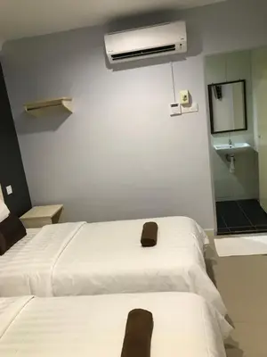 a bedroom with a white bed and a mirror at Hotel Seri Kangsar KK Hotel in Kuala Kangsar