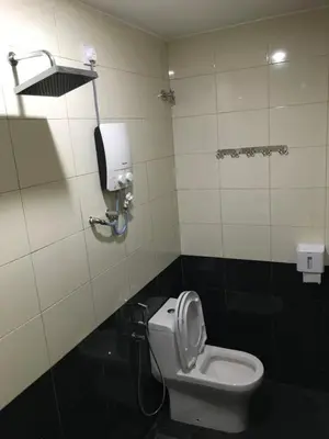 a bathroom with a toilet and a paper dispenser on the wall at Hotel Seri Kangsar KK Hotel in Kuala Kangsar