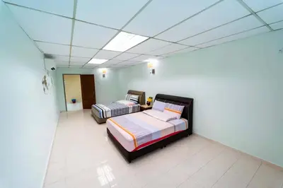 two beds in a room with a ceiling at Star Light Homestay in Sitiawan