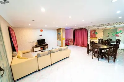 a living room with a couch and a dining room at Star Light Homestay in Sitiawan