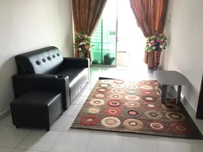 a living room with a couch and a chair and a rug at Wany Homestay & Guest House in Sungai Petani