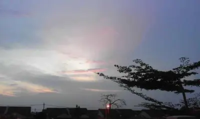 a cloudy sky with a red traffic light and a tree at Wany Homestay & Guest House in Sungai Petani
