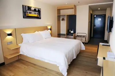 a bedroom with a large white bed and a television at Rivertel in Teluk Intan