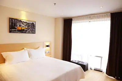 a bedroom with a large white bed and a window at Rivertel in Teluk Intan