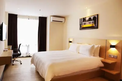 a hotel room with a large bed and a desk at Rivertel in Teluk Intan