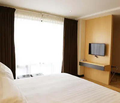 a hotel room with a bed and a tv at Rivertel in Teluk Intan