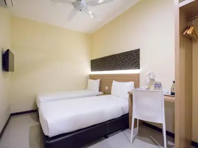 a bedroom with a bed and a table and a chair at 118 Hotel Macalister in George Town
