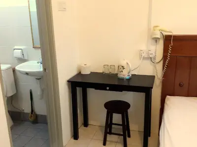 a bathroom with a table with a stool and a sink at Fun Studio Pangkor in Pangkor