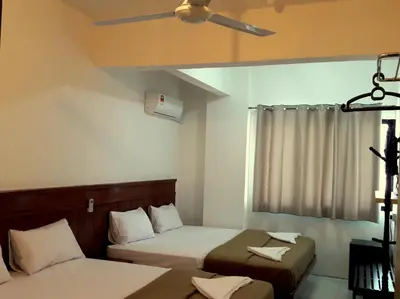 a bedroom with two beds and a ceiling fan at Fun Studio Pangkor in Pangkor