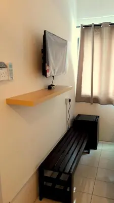 a room with a bench with a tv on a wall at Fun Studio Pangkor in Pangkor