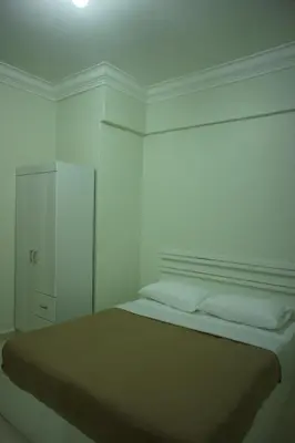 a white room with a bed and a cabinet at Cameron View Apartment @ Crown Imperial Court Brinchang in Cameron Highlands