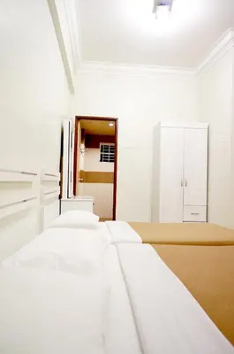a row of white beds in a room at Cameron View Apartment @ Crown Imperial Court Brinchang in Cameron Highlands