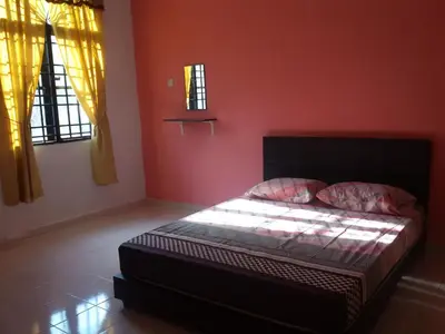 a bedroom with a bed with red walls and windows at Homestay D-Zara in Ipoh