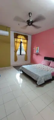 a bedroom with a bed and a red wall at Homestay D-Zara in Ipoh