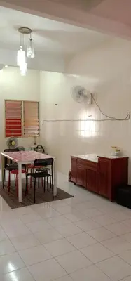 a living room with a table and a kitchen at Homestay D-Zara in Ipoh