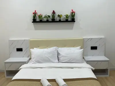 a bedroom with a bed with two night stands and two plants at Home Away from Home in Taiping - 3R4B Family & Group Friendly! in Taiping