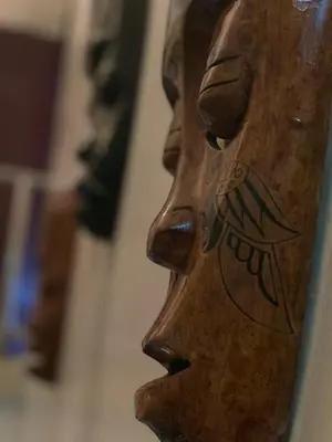a wooden statue of a face on a wall at Ct Hotel in Sitiawan
